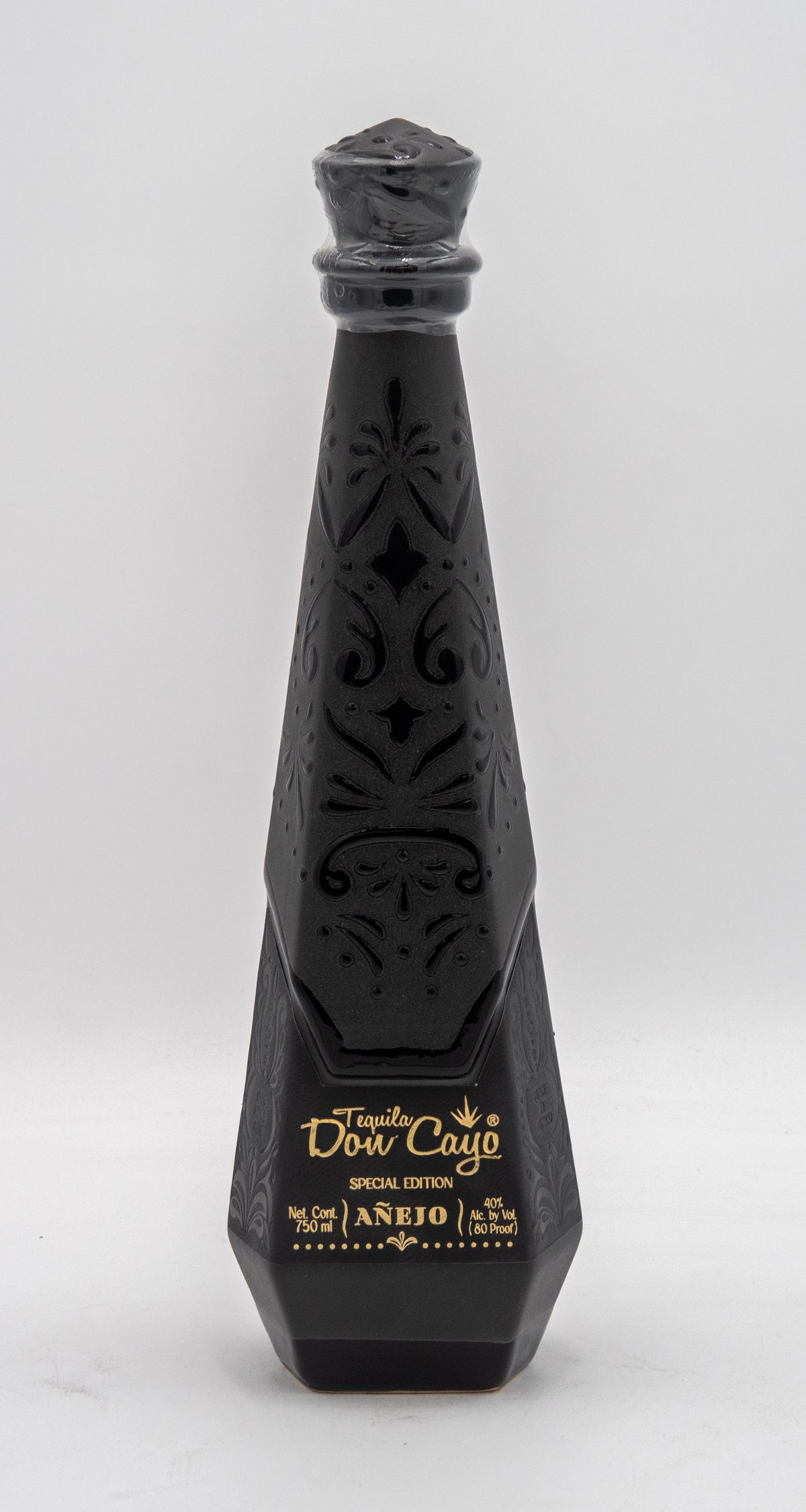 Black decorative bottle with intricate designs on a white background