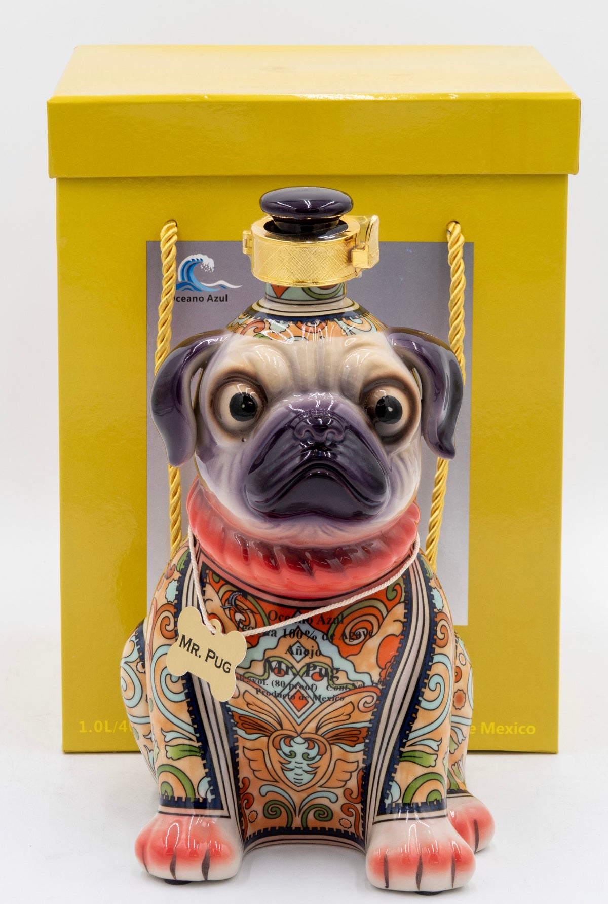 Decorative dog-shaped bottle with intricate patterns in a yellow box on a white background