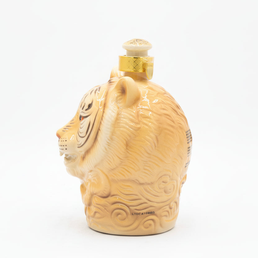 Lion-shaped bottle with gold accents on a white background