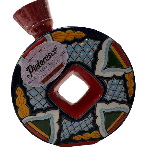 Decorative ceramic plate with colorful patterns and a bottle of wine on a white background